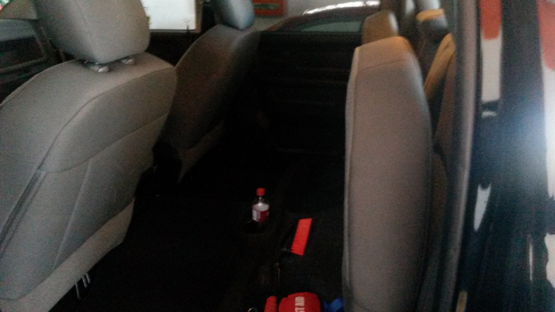 The back seat folded up, with space underneath where I usually keep my hitch, tow straps, and other emergency items.